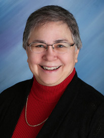 Dr. Elaine Berry in a black jacket and red sweater.