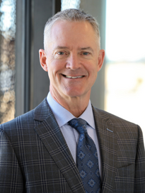 man wearing black sport coat looking and smiling at the camera