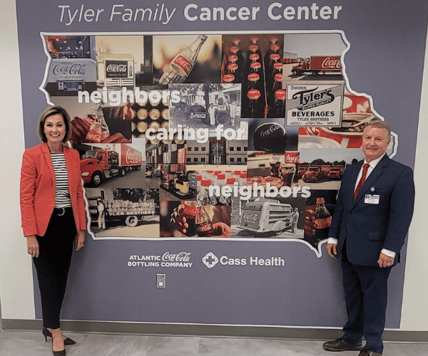 Gov. Reynolds stands next to the Tyler Family Cancer Center mural with CEO Brett Altman.